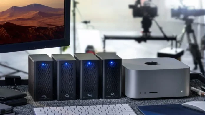 Multiple OWC Express 4M2 Ultra units placed beside Apple Mac Studio in a professional desktop workspace