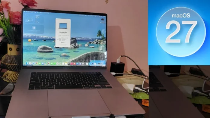 MacBook Pro laptop displaying macOS 27 interface with desktop widgets, dock icons, system window, and lake wallpaper, placed on a desk with charger and accessories visible