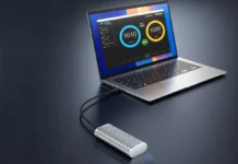 TerraMaster D1 Rugged SSD Enclosure With IP67, 1.2-Ton Crush TerraMaster D1 rugged SSD enclosure connected to a laptop via USB Type C cable displaying high speed data transfer benchmark on screen