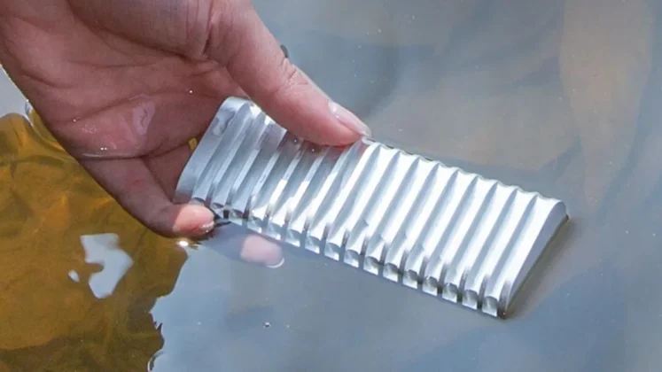 TerraMaster D1 rugged SSD enclosure held partially underwater showing sealed aluminum fins and resistance to liquid exposure