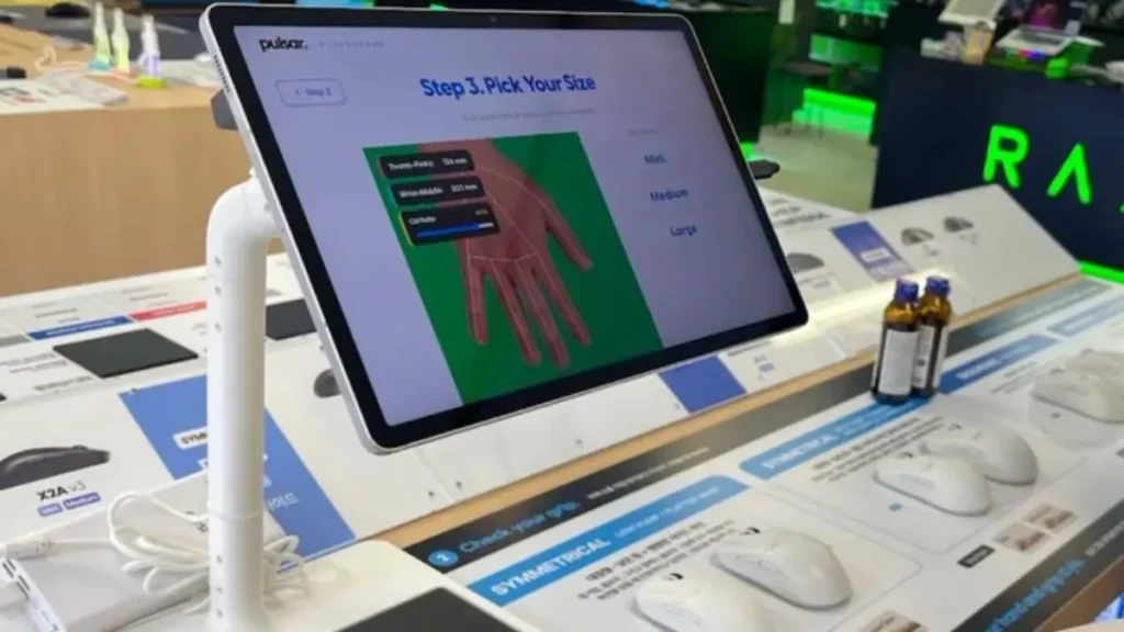 Pulsar Playground AI scanner analyzing hand measurements to recommend the best gaming mouse shape in a retail store