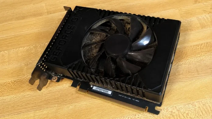 dusty NVIDIA GeForce GTX 1660 Ti graphics card with single-fan cooler on wooden table