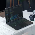 Razer Blade 18 laptop running code editor on a desk setup with gaming mouse