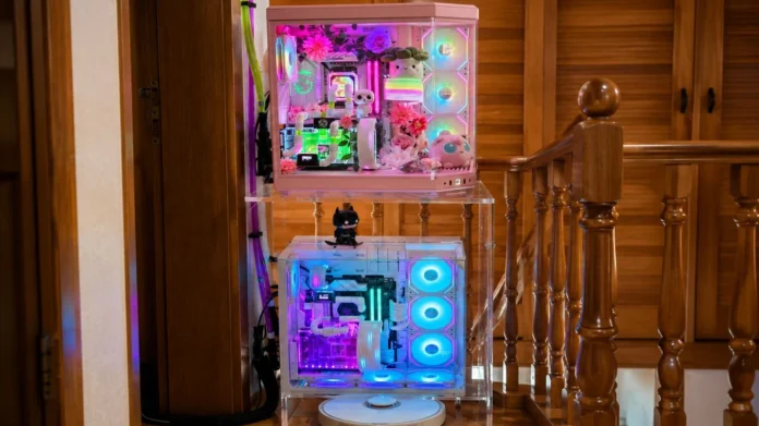 Pair of RGB-lit Ryzen gaming PCs mounted on transparent shelves with custom water cooling