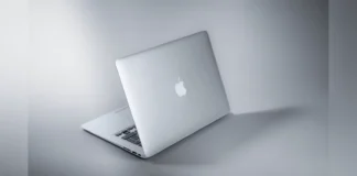Apple Seeks Approval to Buy Memory From Blacklisted Chinese Chipmaker Rear view of an open silver Apple MacBook notebook highlighting the logo.