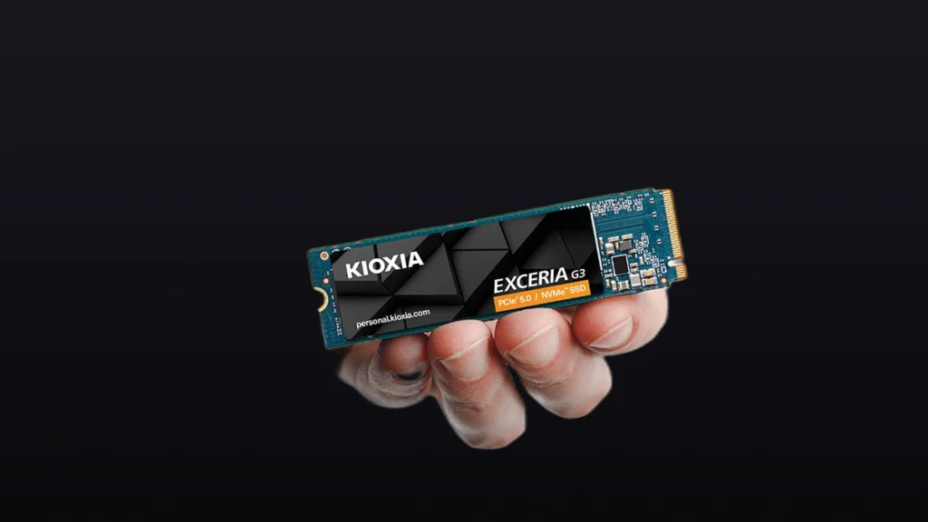 Hand holding the Kioxia EXCERIA G3 PCIe 5.0 NVMe SSD showing the label on a premium dark gradient background.