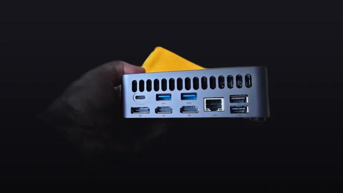 Close-up of the rear panel of the Ninkear M8_226V mini PC showing its ports on a premium dark gradient backdrop.