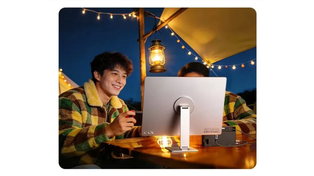 UGREEN AP16 portable monitor being used outdoors for gaming and entertainment.