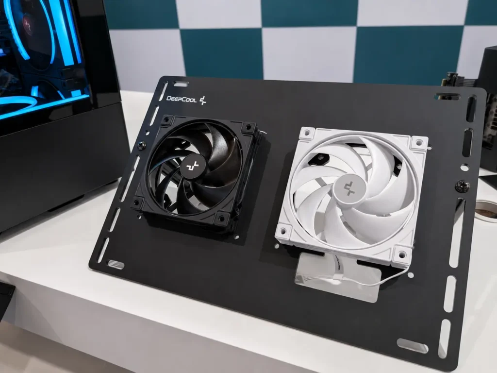 DeepCool FL12 INF and FD12 V2 Fans Bring Cleaner Builds and Quieter Cooling 3 Black and white versions of the DeepCool FD12 V2 case fan mounted on a display board during a product showcase