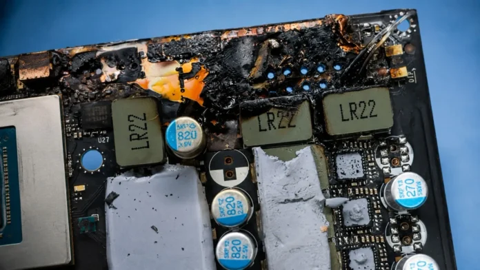 Detailed view of burn damage around the power delivery area on an RTX 5090 graphics card PCB.
