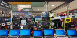 GeForce RTX 5090 and Ryzen 7 9800X3D Sell Without Fixed Prices in China Front counter of a computer shop displaying laptops and stacked GPU boxes in Chengdu's Computer City retail market.