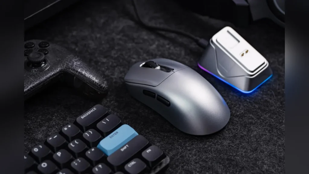 Epomaker Launches NEX Pro Mouse and HE65 V2 TMR Keyboard 2 The silver EPOMAKER NEX Pro gaming mouse on a desk next to its magnetic RGB charging dock.