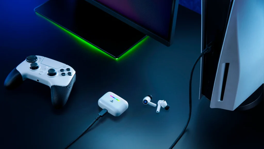 Lifestyle view showing the white Razer Hammerhead V3 X HyperSpeed for PlayStation earbuds next to a DualSense controller and PS5 console.