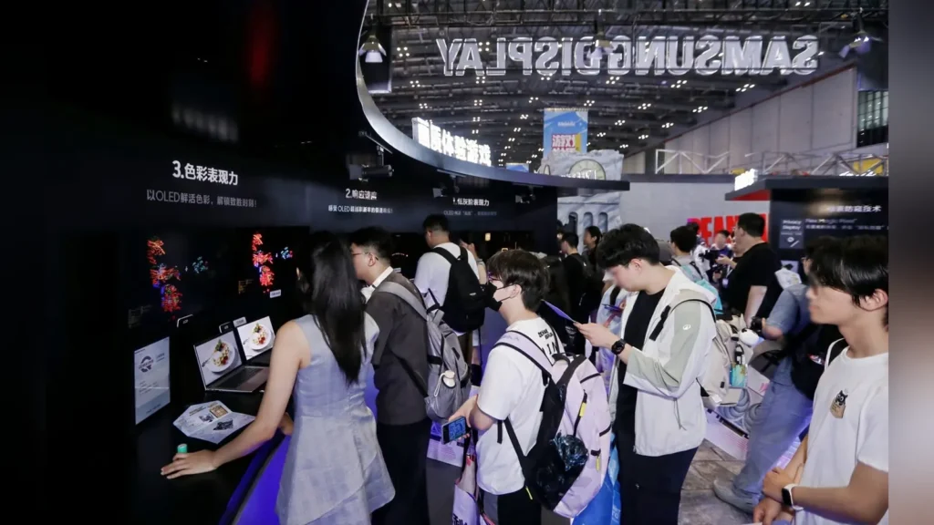 Visitors inspecting the OLED laptop screens and monitor display platforms at the Samsung exhibition booth.