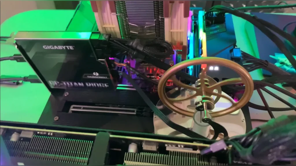 Close-up top-down view of the toy Stirling engine flywheel spinning on the motherboard chipset heatsink.