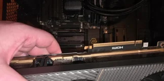 ZOTAC RTX 5090 Reportedly Emits Smoke and Fails During Gameplay A hand holding the ZOTAC GeForce RTX 5090 SOLID graphics card next to the primary PCIe connection slot.