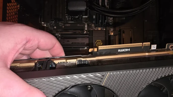 A hand holding the ZOTAC GeForce RTX 5090 SOLID graphics card next to the primary PCIe connection slot.