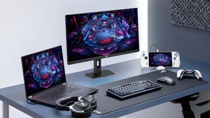 ASUS ROG Strix XG259QNSR Ace gaming monitor in a desktop setup with a gaming laptop, handheld console, keyboard, mouse, headset, and controller.