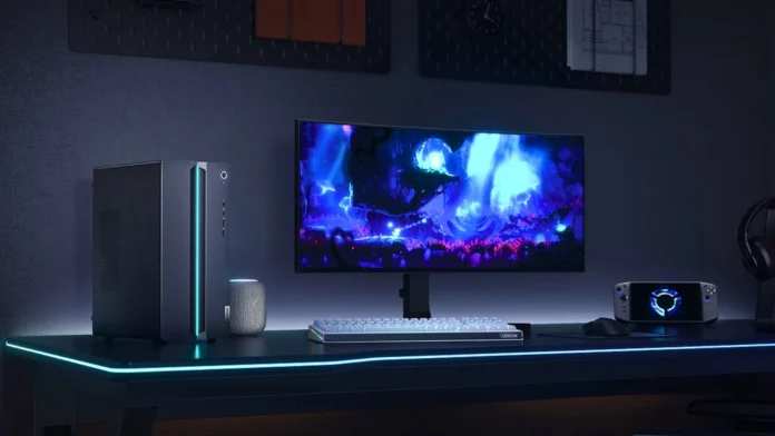 Lenovo GeekPro gaming desktop connected to an ultrawide monitor with RGB lighting, mechanical keyboard, mouse, and handheld gaming device.