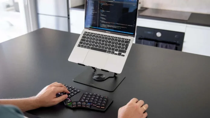 Dygma Sonsei split ergonomic keyboard paired with a laptop on a desktop workstation