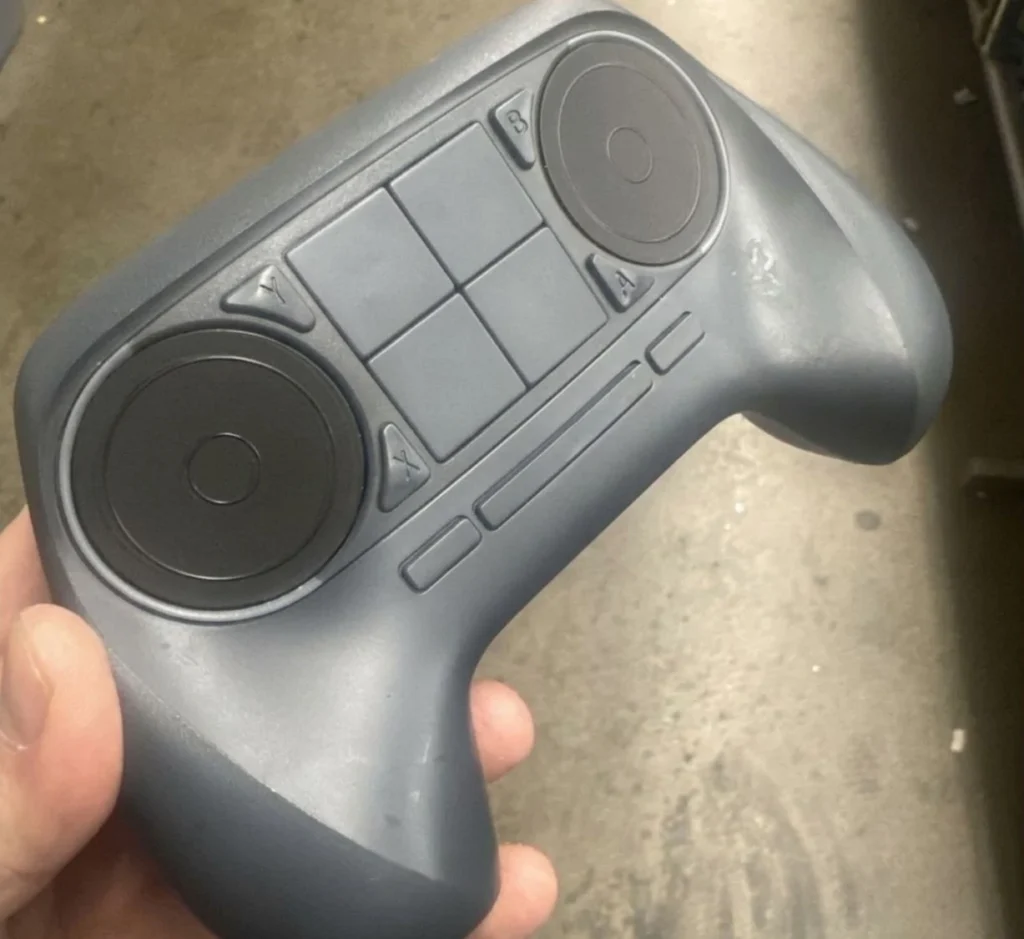 Close-up view of the Valve Steam Controller showing its dual circular trackpads, central control buttons, and ergonomic grip after being found at a Goodwill thrift store.