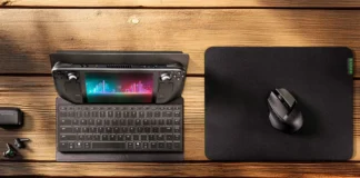 Razer Travel Case Folio Turns Into a Stand for Portable Keyboards Razer Travel Case Folio with handheld gaming console, keyboard, mouse, and earbuds on a wooden desk.