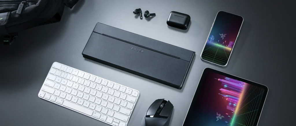 Razer Travel Case Folio with compact keyboard, wireless mouse, earbuds, smartphone, and tablet.